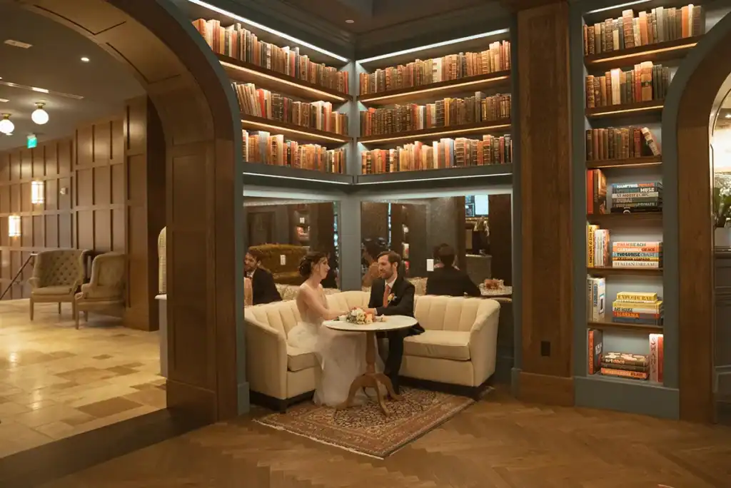 Cozy library lounge with plush seating, filled with extensive bookshelves, perfect for relaxing stays.