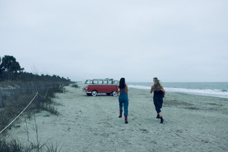Two women running on an open beach in Charleston